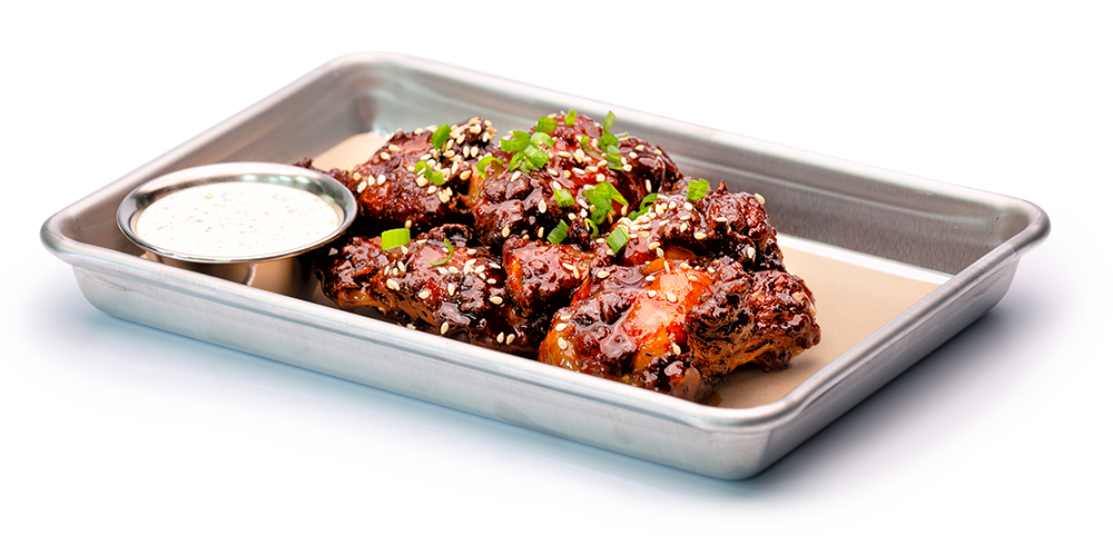 Asian style chicken wings with sauce on silver serving tray